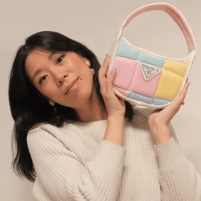Woman In White Sweater Holding Prada Purse GIF
