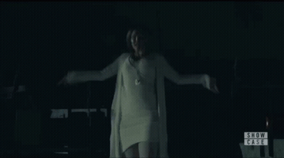 Woman In White Sweater In Front Of Show Case Sign GIF