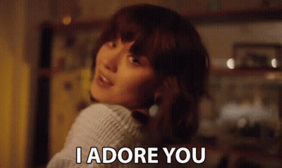 Woman In White Sweater Looking Over Shoulder Says I Adore You GIF