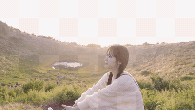 Woman in White Sweater Sitting in Field