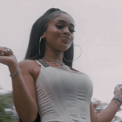 Woman In White Tank Top And Hoop Earrings Under Cloudy Sky GIF