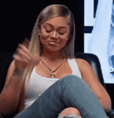 Woman In White Tank Top And Jeans Sitting Crossed Legs GIF