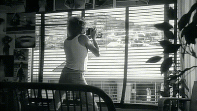 Woman In White Tank Top By Window GIF