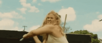 Woman In White Tank Top Holding Sword With Funny Face GIF
