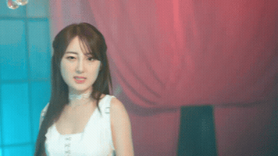 Woman In White Tank Top In Front Of Pink Curtain GIF