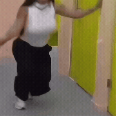 Woman In White Tank Top Kneeling Before Yellow Door GIF