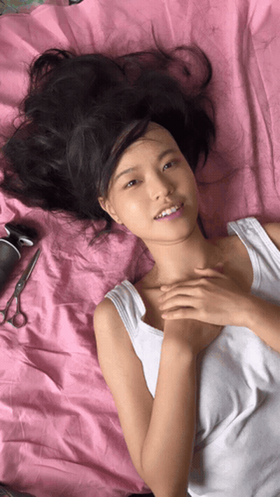 Woman In White Tank Top Laying On Bed GIF