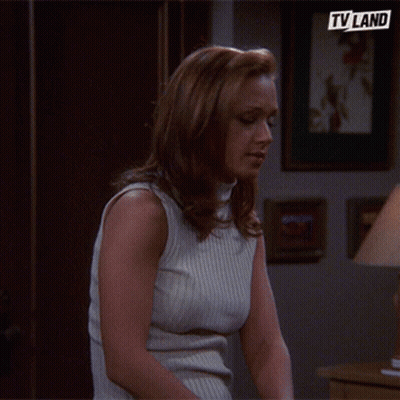 Woman In White Tank Top Sitting With TV Land Logo GIF