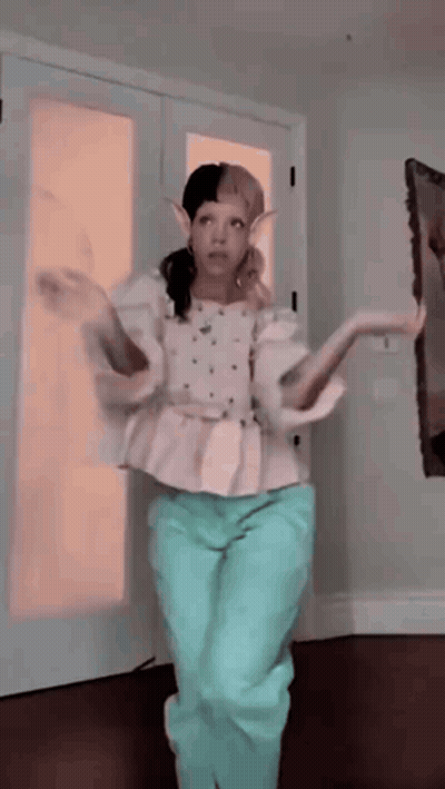 Woman In White Top And Blue Pants Dancing GIF
