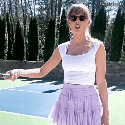 Woman In White Top And Purple Skirt Holding Tennis Racquet GIF