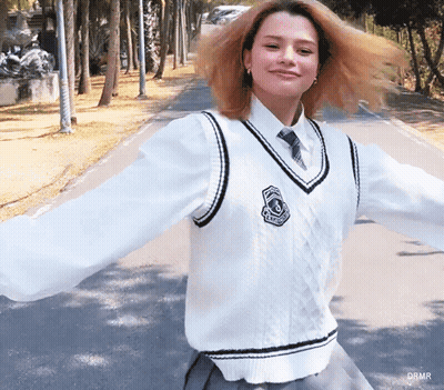 Woman In White Vest And Tie With Drmr Badge GIF