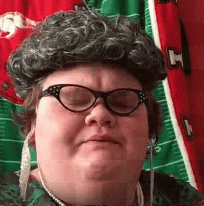 Woman In Wig And Glasses Making Funny Face GIF