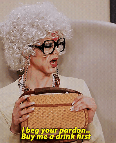 Woman In Wig And Glasses Saying I Beg Your Pardon Buy Me A Drink GIF
