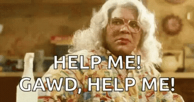 Woman In Wig And Glasses Sitting In Kitchen GIF