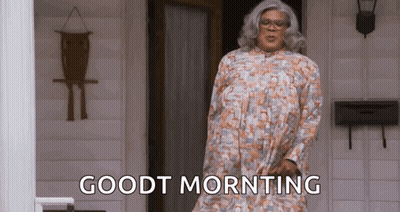 Woman In Wig And Glasses Sitting In Kitchen GIF