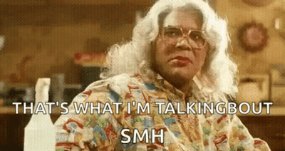 Woman In Wig And Glasses Sitting With Spray Bottles GIF