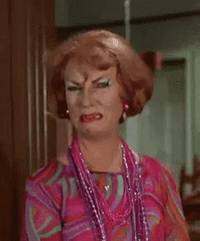 Woman In Wig And Necklace Making A Face GIF