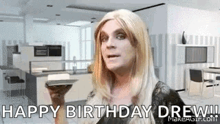 Woman In Wig Holding Book Says Happy Birthday Drew GIF