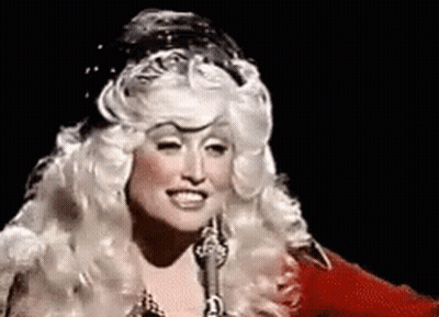Woman In Wig Singing Into Microphone And Smiling GIF