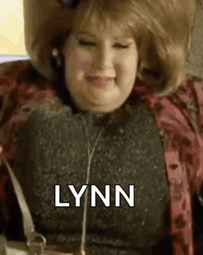 Woman In Wig Smiling Holding Purse GIF
