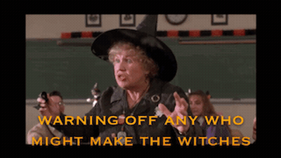 Woman In Witch Hat Warning Off Witches GIF