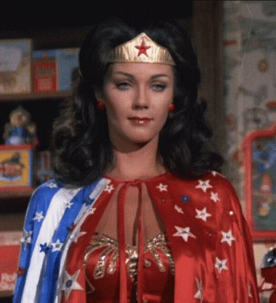 Woman In Wonder Woman Costume In Front Of Bookshelf GIF
