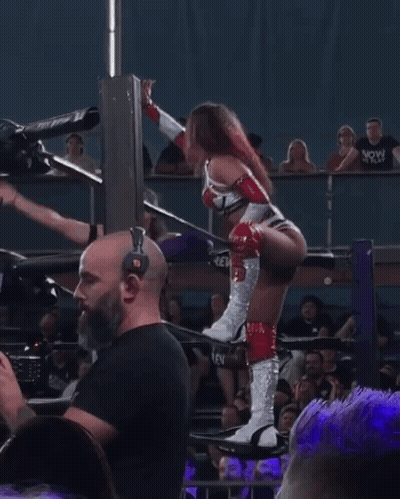 Woman In Wrestling Ring With Bearded Man Behind Her GIF