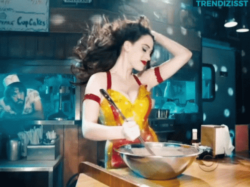 Woman In Yellow And Red Dress Stirring Bowl GIF