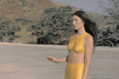 Woman In Yellow Bikini On Sandy Beach GIF
