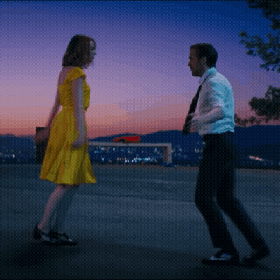 Woman In Yellow Dress Dancing With Man In Suit GIF
