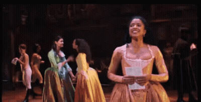 Woman In Yellow Dress Holding Paper Smiling GIF