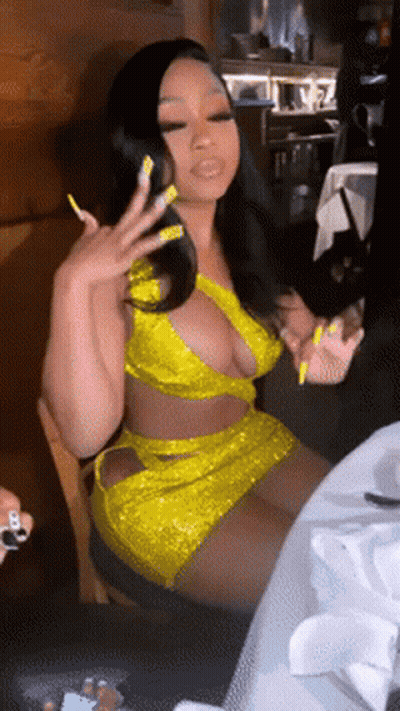 Woman In Yellow Dress Sitting At Table GIF