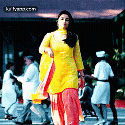 Woman In Yellow Dress Standing Before Crowd GIF