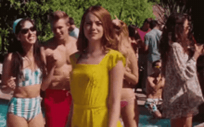 Woman In Yellow Dress Standing In Front Of Pool With Crowd GIF