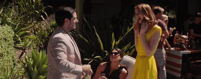 Woman in Yellow Dress Talking to Man in Suit