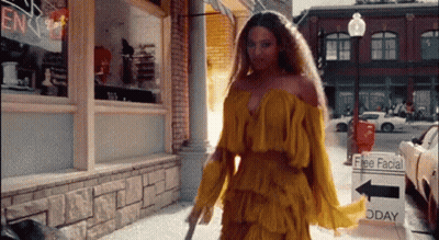 Woman in Yellow Dress Walking Down City Street