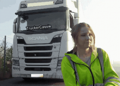 Woman In Yellow Jacket In Front Of White Scania Truck GIF