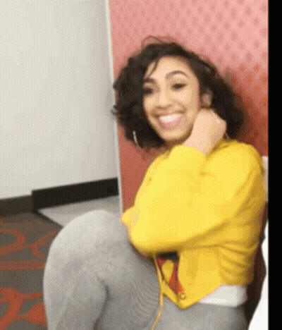 Woman In Yellow Jacket Sitting On Chair Smiling GIF