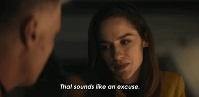 Woman In Yellow Jacket Talking To Man In Dark Room GIF