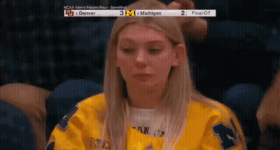 Woman In Yellow Jersey Watching Game At Stadium GIF