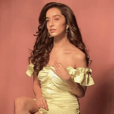 Woman In Yellow Off-Shoulder Dress Sitting On Pink Background GIF