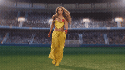 Woman In Yellow Outfit Walking On Soccer Field GIF
