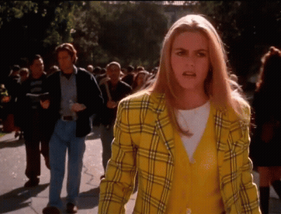 Woman In Yellow Plaid Jacket Talking To Crowd GIF