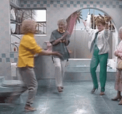 Woman In Yellow Shirt Dancing In Bathroom With Others GIF