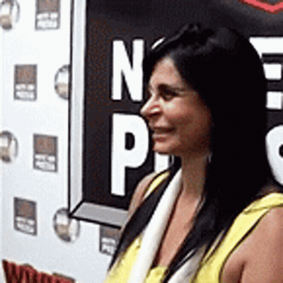 Woman In Yellow Shirt In Front Of NP Sign GIF