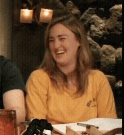 Woman In Yellow Shirt Laughing At Table With Others GIF