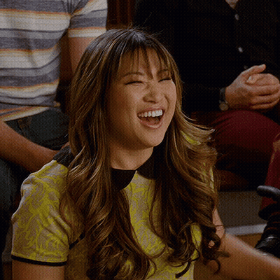 Woman In Yellow Shirt Laughing In Crowd GIF
