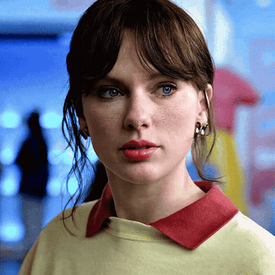 Woman In Yellow Shirt With Red Collar And Earrings GIF