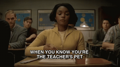 Woman in Yellow Sweater Sitting at Classroom Desk