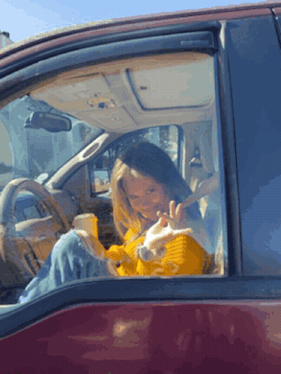 Woman In Yellow Sweater Sitting In Red Car GIF